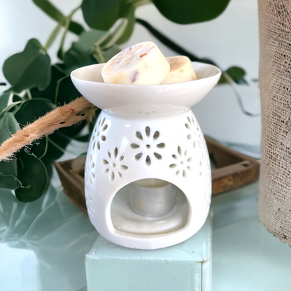 a white oil burner with soy wax melt pods and decorative eucalyptus plant